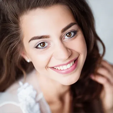 An attractive young woman smiling, showing straight, white teeth